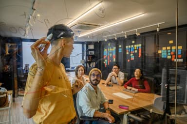 Team bespreekt ideeën bij een glazen bord in een kantoor