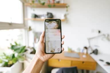 Hand houdt een smartphone vast met meldingen op het scherm