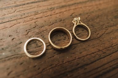 Drie gouden ringen op een houten ondergrond