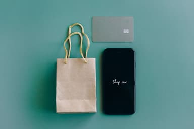 Papieren tasje, betaalkaart en smartphone op een groene ondergrond