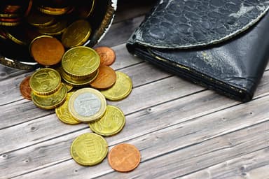 Versleten portemonnee met euromunten op een houten tafel