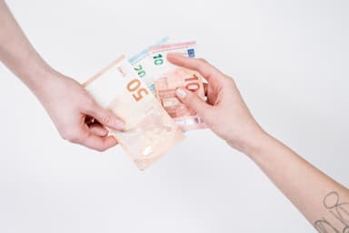Twee handen geven elkaar eurobiljetten