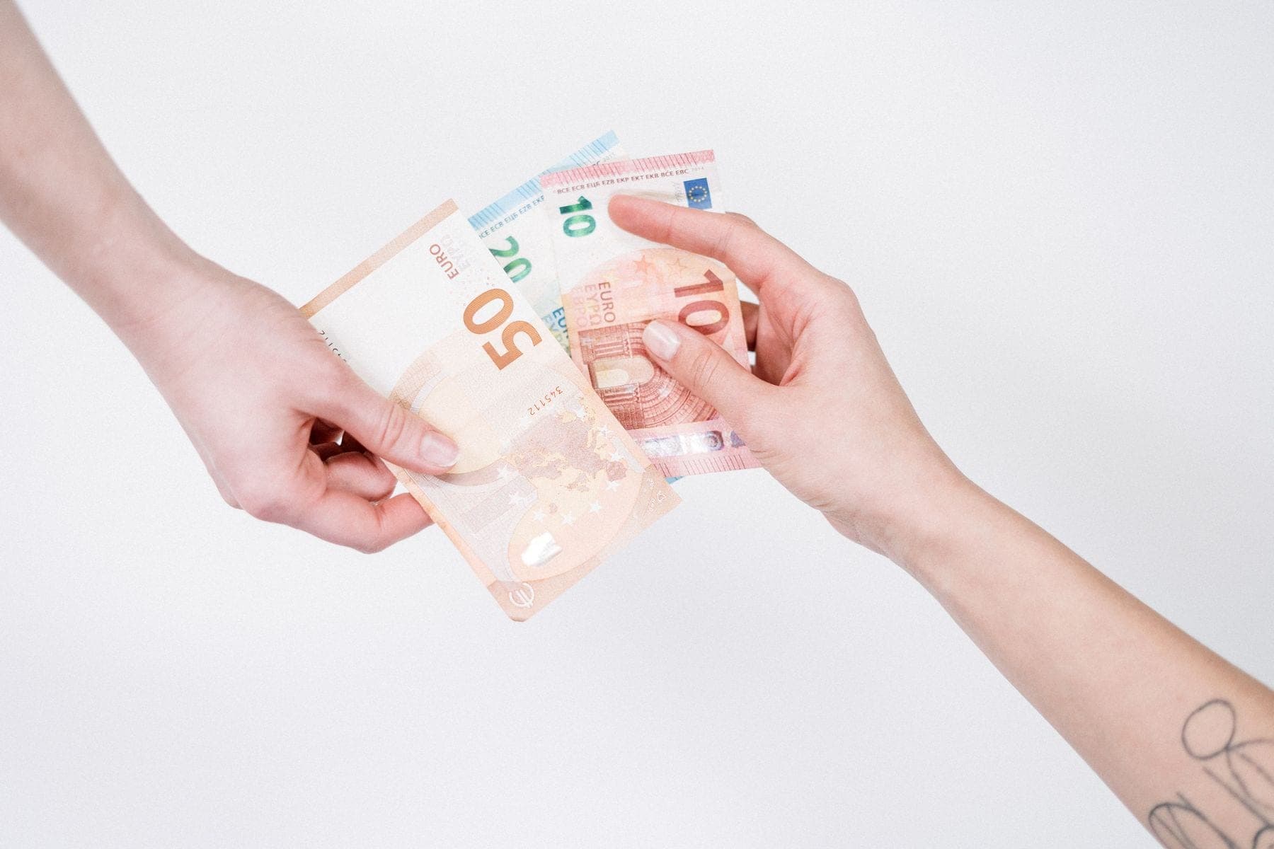 Twee handen geven elkaar eurobiljetten