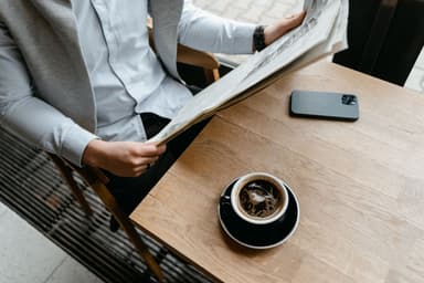 Man leest de krant bij een kop koffie