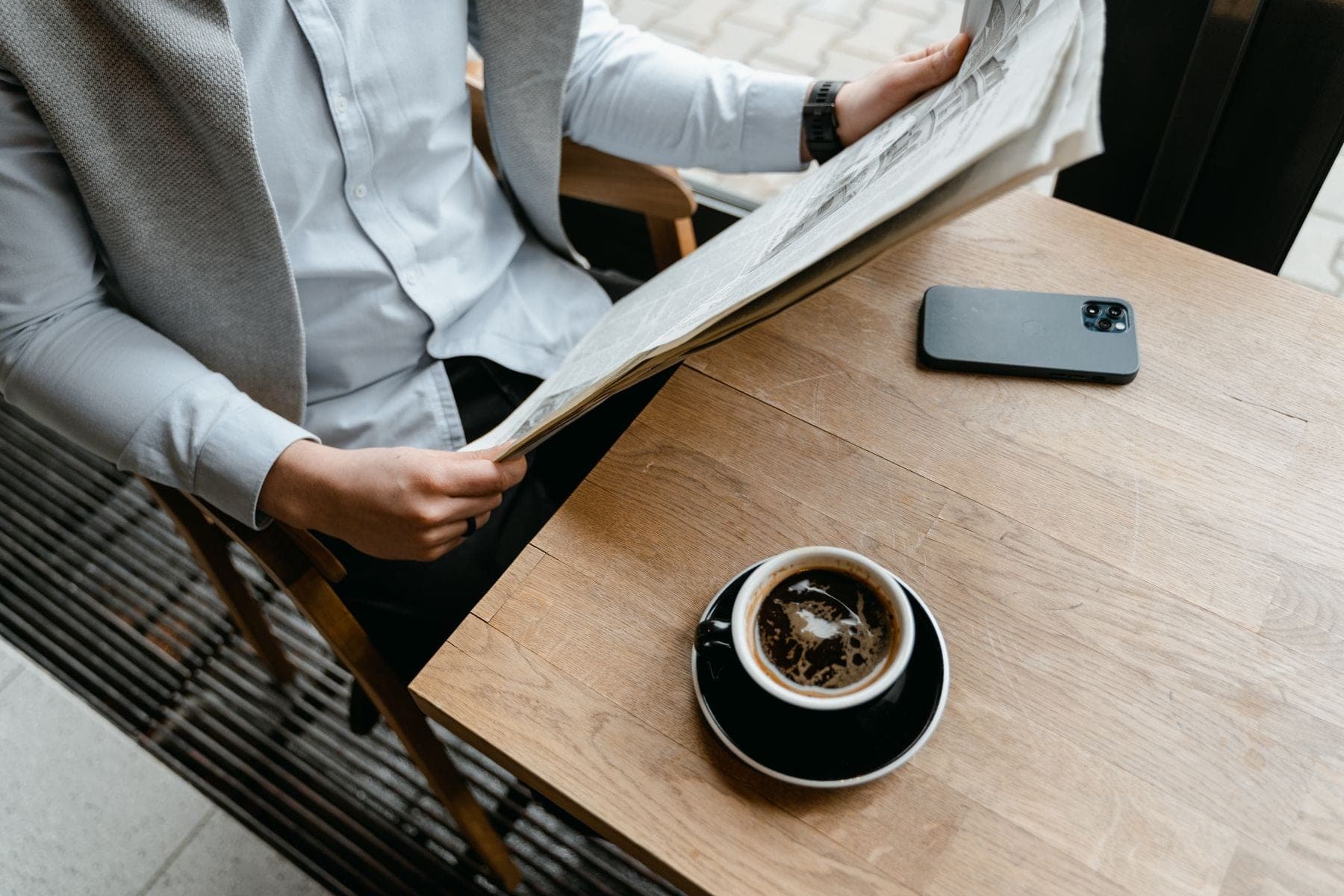 Man leest de krant bij een kop koffie