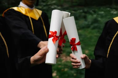 Afgestudeerden houden hun diploma omhoog