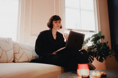 Vrouw op de bank met een laptop thuis