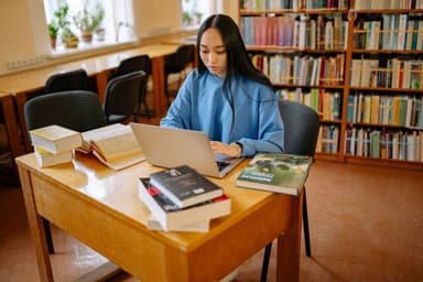 Student aan het studeren met laptop en boeken
