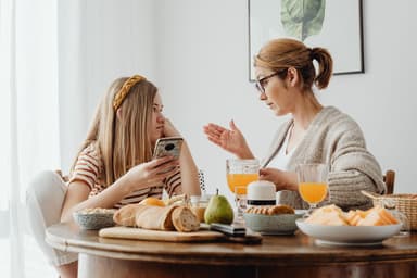Moeder en dochter in gesprek aan de ontbijttafel