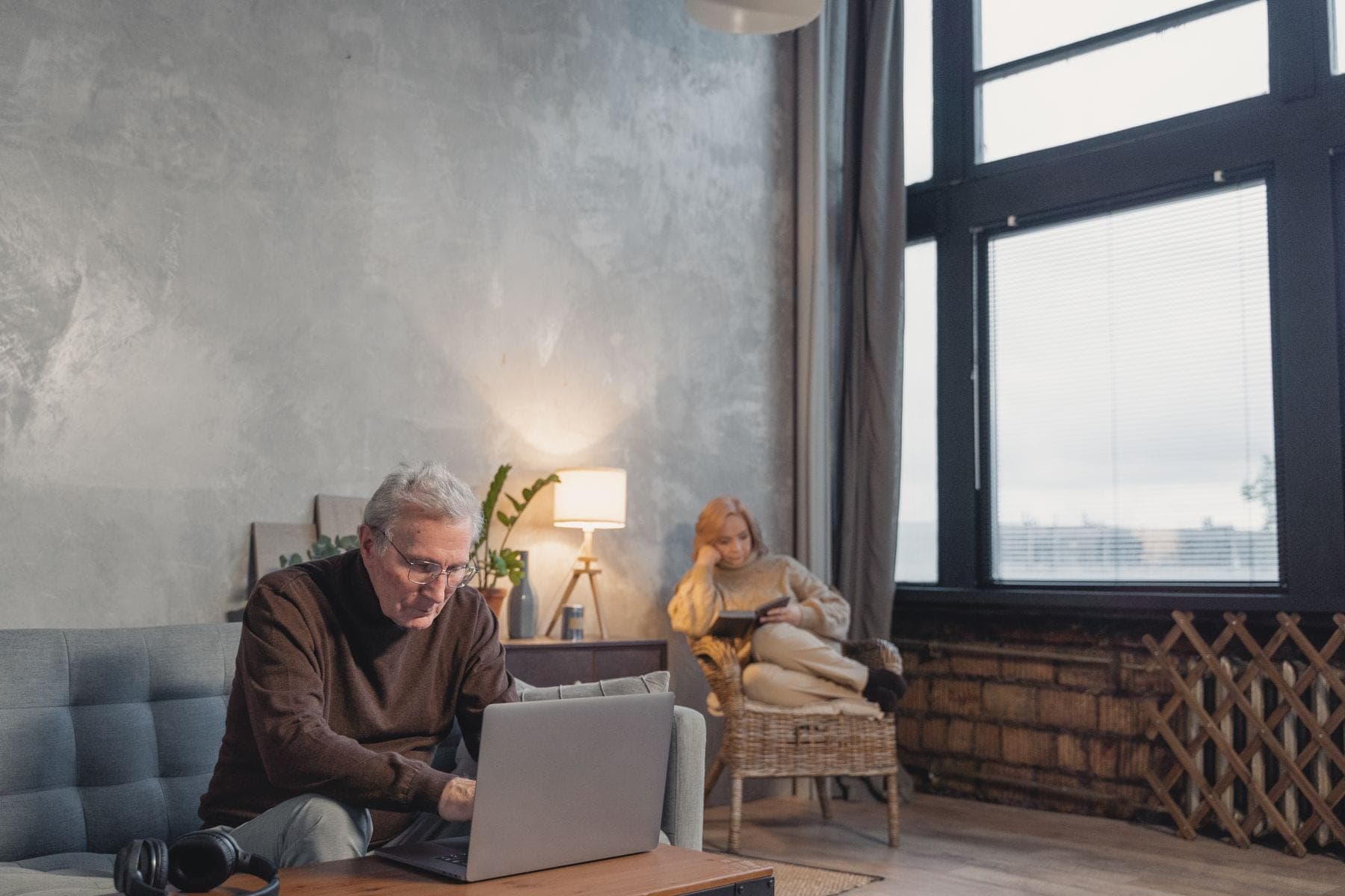Oudere man werkt op een laptop in zijn woonkamer