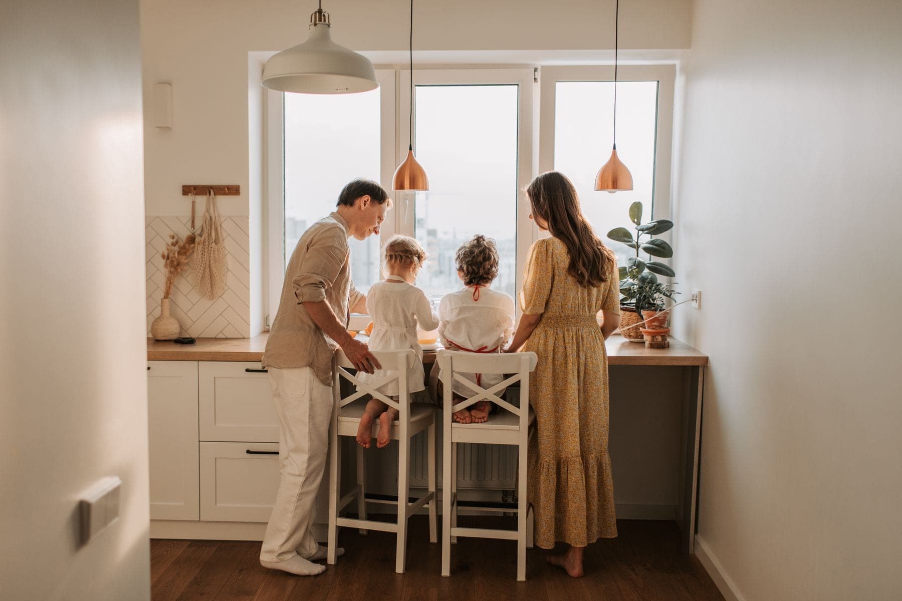 Gezin met twee kinderen aan de keukentafel, gezien van achteren