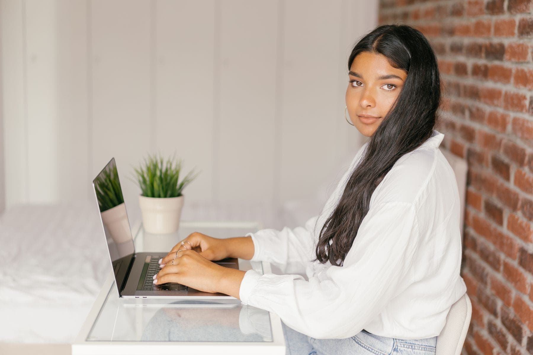 Jonge vrouw werkt thuis aan een bureau op een laptop